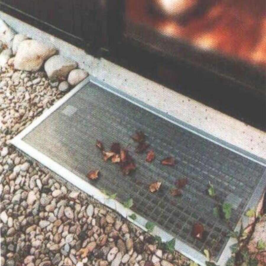 Lüftungsschacht im Garten vor Terrassentür mit Fliegengitter am Lüftungsfenster.