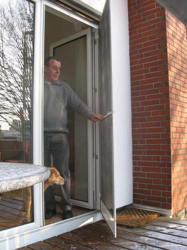 Drehtür mit Fliegengitter, Mann mit Hund als Größenvergleich.