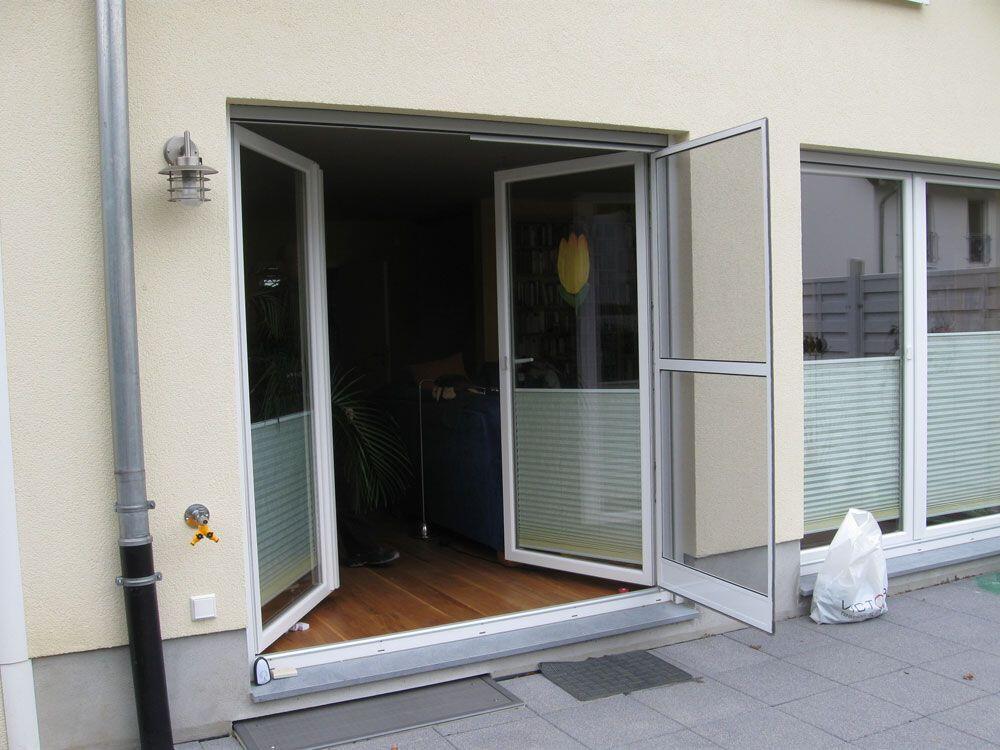 Zweiflügelige Eingangs-Pendeltür mit Fliegengitter auf einem Flügel.